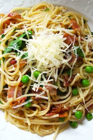 bowl of spaghetti with bacon, peas and chilies
