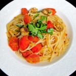 bowl of spaghetti with cherry tomatoes and basil