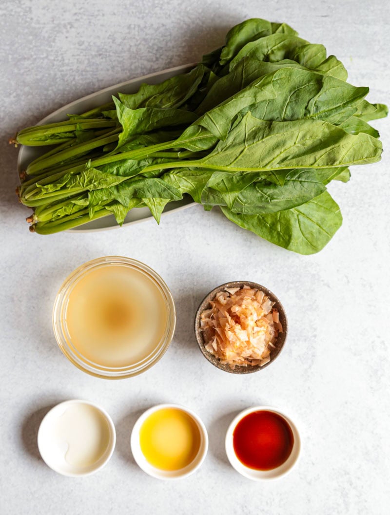 Ingredients for spinach ohitashi including spinach, dashi, soy sauce, mirin, sesame oil, and bonito flakes