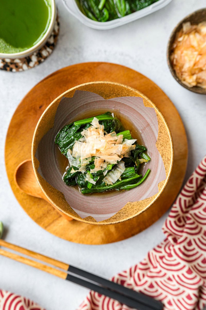 Japanese spinach ohitashi served with dashi broth and bonito flakes