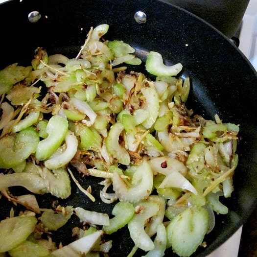 sliced celery pan frying with garlic and ginger
