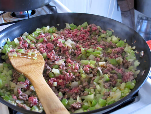 ground beef cooking with vegetable in a pan.