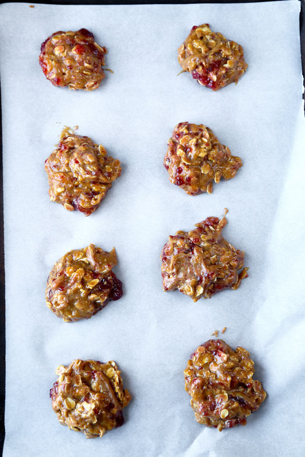 Gluten-free goodness! Chewy, sweet and fruity, these gluten-free peanut butter and raspberry jam cookies are so good you won't be able to stop at just one! #glutenfreecookies #glutenfreerecipes #flourless #homemadecookies | pickledplum.com