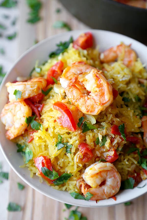 Shrimp scampi spaghetti squash - salty, lemony, buttery shrimp over a healthy bowl of spaghetti squash tossed in savory parmesan cheese. Totally yummy and ready in just 25 minutes! | pickledplum.com