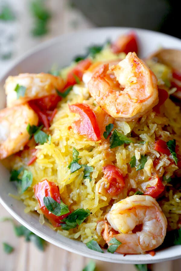 Shrimp scampi spaghetti squash - salty, lemony, buttery shrimp over a healthy bowl of spaghetti squash tossed in savory parmesan cheese. Totally yummy and ready in just 25 minutes! | pickledplum.com