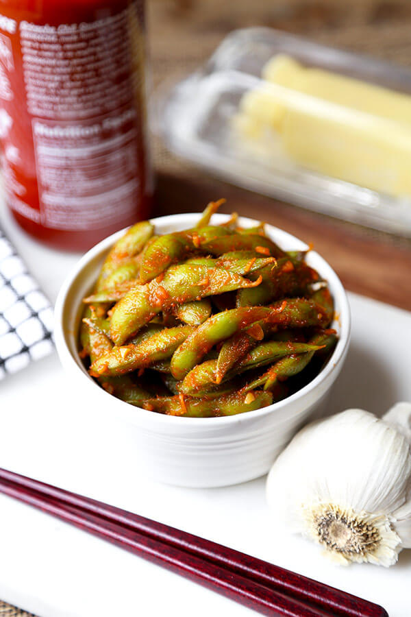 Edamame with Sriraracha Buffalo Sauce - Tangy, garlicky and buttery edamame with sriracha Buffalo sauce - this is a great way to pack on plenty of flavor without adding fat or calories! Recipe, easy, healthy, gluten free, snack | pickledplum.com