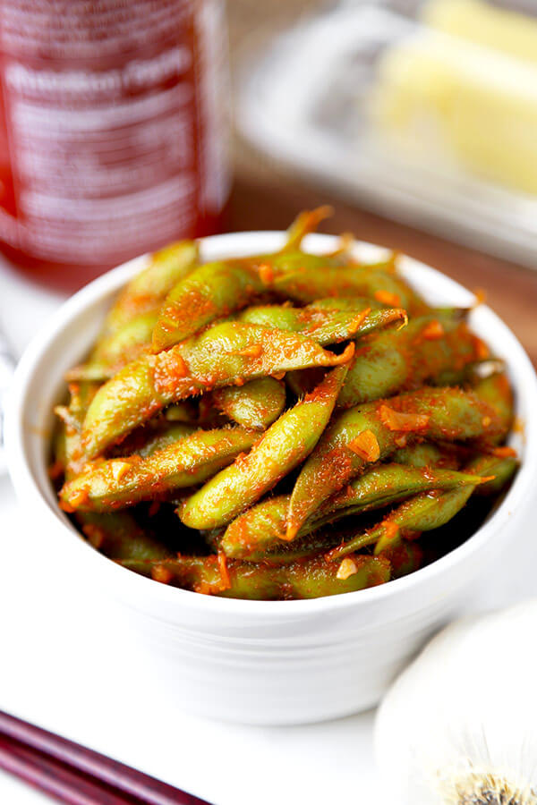 Edamame with Sriraracha Buffalo Sauce - Tangy, garlicky and buttery edamame with sriracha Buffalo sauce - this is a great way to pack on plenty of flavor without adding fat or calories! Recipe, easy, healthy, gluten free, snack | pickledplum.com