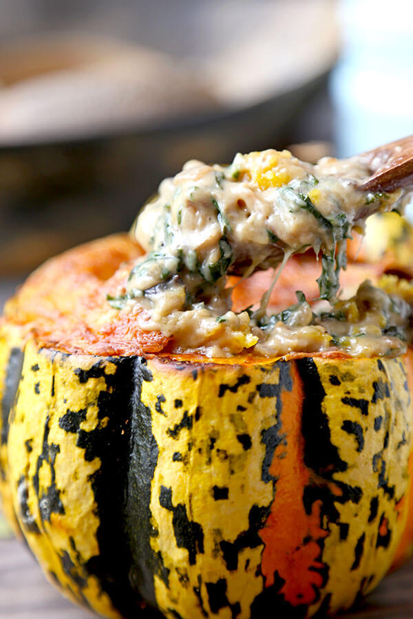 Cheesy Baked Acorn Squash - A delicious fall recipe your entirely family will love (and it looks so pretty!). Roasted acorn squash stuffed with cheese, baby kale and a creamy mushroom sauce. This is an easy dinner recipe, comfort food for the fall and winter. #fallrecipes #acornsquash #homemade #yummy | pickledplum.com