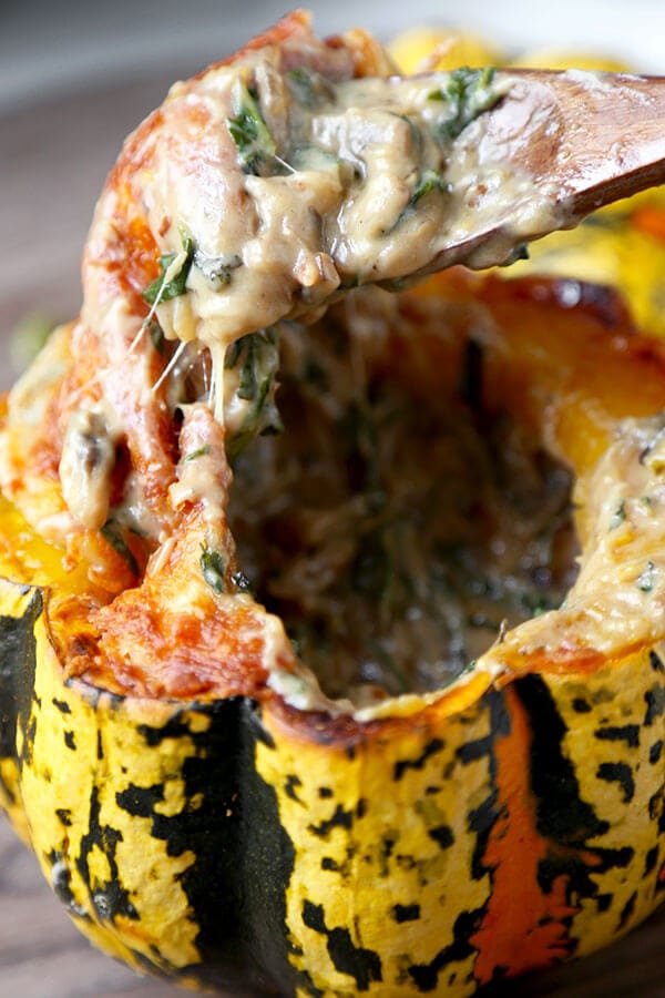 Cheesy Baked Acorn Squash - A delicious fall recipe your entirely family will love (and it looks so pretty!). Roasted acorn squash stuffed with cheese, baby kale and a creamy mushroom sauce. This is an easy dinner recipe, comfort food for the fall and winter. #fallrecipes #acornsquash #homemade #yummy | pickledplum.com