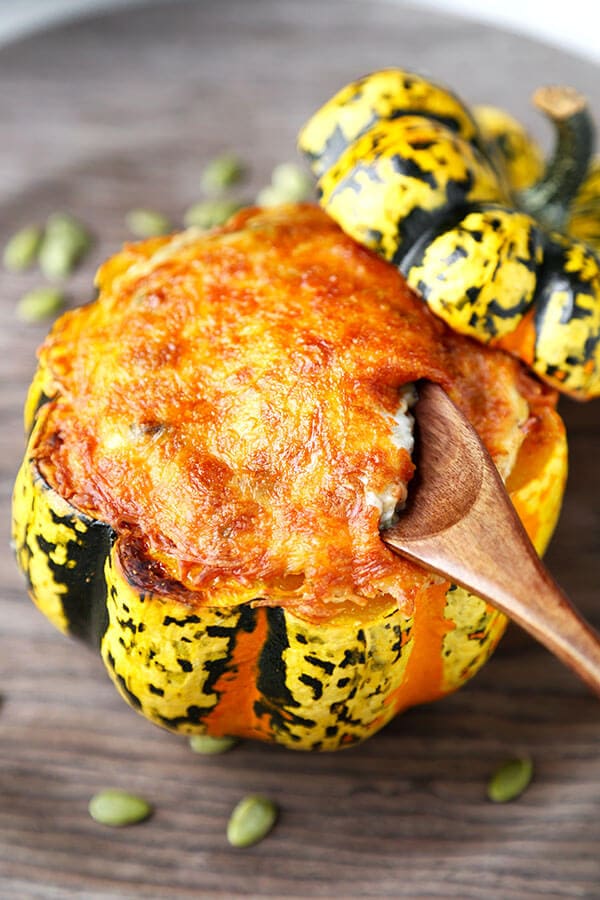 Cheesy Baked Acorn Squash - A delicious fall recipe your entirely family will love (and it looks so pretty!). Roasted acorn squash stuffed with cheese, baby kale and a creamy mushroom sauce. This is an easy dinner recipe, comfort food for the fall and winter. #fallrecipes #acornsquash #homemade #yummy | pickledplum.com