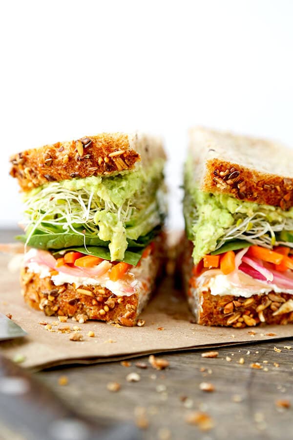 California Veggie Sandwich - There is nothing boring about this veggie sandwich! Work your way through layers and layers of bold flavors in this California veggie sandwich with pickled carrots, mashed avocado, lemony goat cheese spread, cucumbers, sprouts and baby spinach. Recipe, sandwich, snack, healthy, vegetables | pickledplum.com