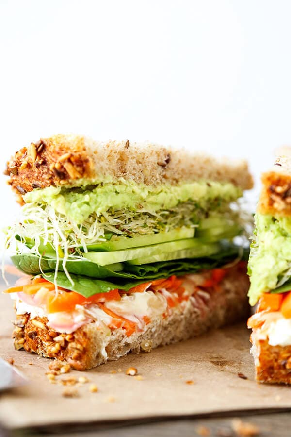 California Veggie Sandwich - There is nothing boring about this veggie sandwich! Work your way through layers and layers of bold flavors in this California veggie sandwich with pickled carrots, mashed avocado, lemony goat cheese spread, cucumbers, sprouts and baby spinach. Recipe, sandwich, snack, healthy, vegetables | pickledplum.com