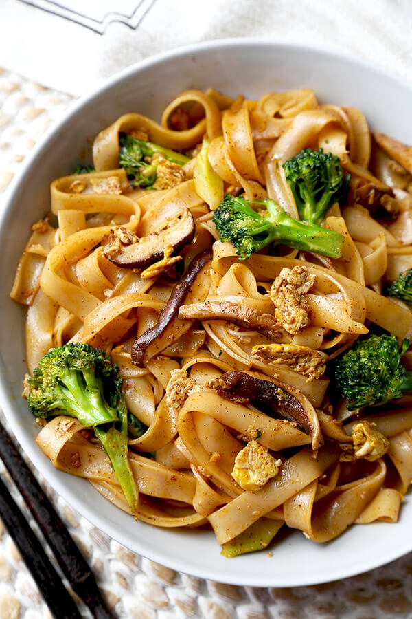 Veggie Pad See Ew - Chew on these savory Thai rice noodles in less than 16 minutes! This a traditional Pad See Ew recipe made with all broccoli and mushrooms and sprinkled with plenty of chili powder. Recipe, Thai food, Asian noodles, stir fry, vegetables | pickledplum.com