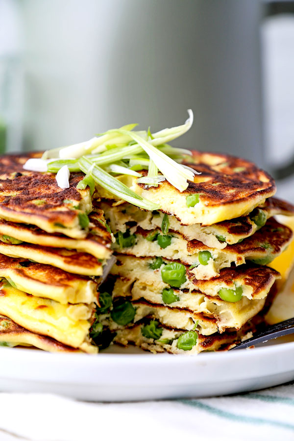 Spring Pea Pancakes - A bright and pillowy soft Spring Pea Pancakes Recipe. These small savory pancakes have the verdant pop of fresh green peas. Find out how to choose the best fresh peas - and info on frozen vs fresh spring peas. It’s springtime on a plate! #pancakes #healthyeating #brunch #peas | pickledplum.com