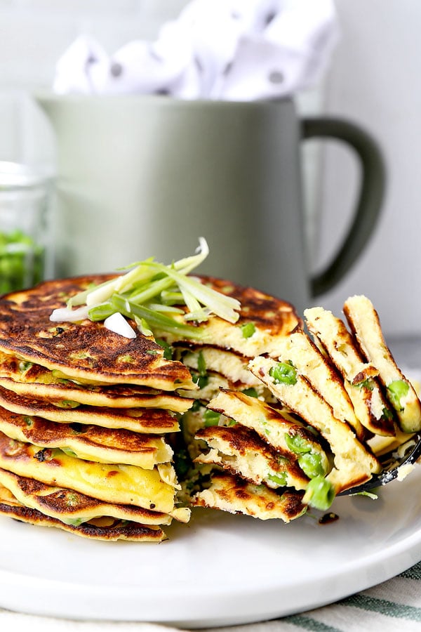 Spring Pea Pancakes - A bright and pillowy soft Spring Pea Pancakes Recipe. These small savory pancakes have the verdant pop of fresh green peas. Find out how to choose the best fresh peas - and info on frozen vs fresh spring peas. It’s springtime on a plate! #pancakes #healthyeating #brunch #peas | pickledplum.com