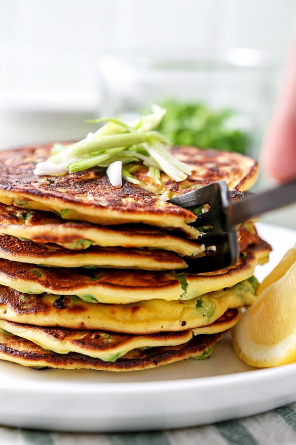 Spring Pea Pancakes - A bright and pillowy soft Spring Pea Pancakes Recipe. These small savory pancakes have the verdant pop of fresh green peas. Find out how to choose the best fresh peas - and info on frozen vs fresh spring peas. It’s springtime on a plate! #pancakes #healthyeating #brunch #peas | pickledplum.com