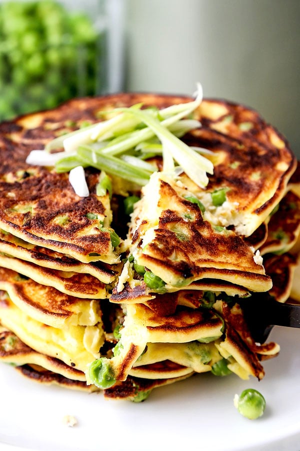 Spring Pea Pancakes - A bright and pillowy soft Spring Pea Pancakes Recipe. These small savory pancakes have the verdant pop of fresh green peas. Find out how to choose the best fresh peas - and info on frozen vs fresh spring peas. It’s springtime on a plate! #pancakes #healthyeating #brunch #peas | pickledplum.com