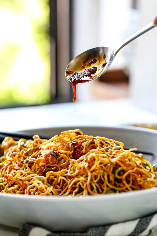Pan Fried Noodles With Tangy Chili Crisp Sauce - Blanketed with herbs and plenty of smokey, pungent, fragrant heat, this pan fried noodles recipe is ready in under 20 minutes from start to finish! #eggnoodles #chineserecipes #noodlerecipe #stirfry #veganrecipes | pickledplum.com