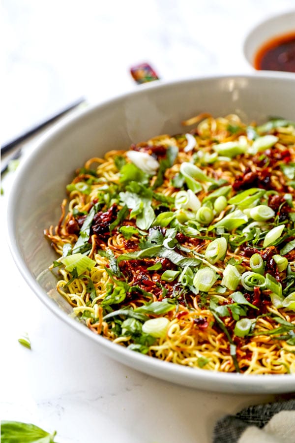 Pan Fried Noodles With Tangy Chili Crisp Sauce - Blanketed with herbs and plenty of smokey, pungent, fragrant heat, this pan fried noodles recipe is ready in under 20 minutes from start to finish! #eggnoodles #chineserecipes #noodlerecipe #stirfry #veganrecipes | pickledplum.com