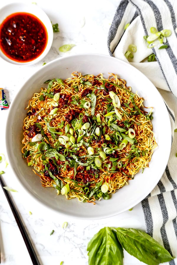 Pan Fried Noodles With Tangy Chili Crisp Sauce - Blanketed with herbs and plenty of smokey, pungent, fragrant heat, this pan fried noodles recipe is ready in under 20 minutes from start to finish! #eggnoodles #chineserecipes #noodlerecipe #stirfry #veganrecipes | pickledplum.com