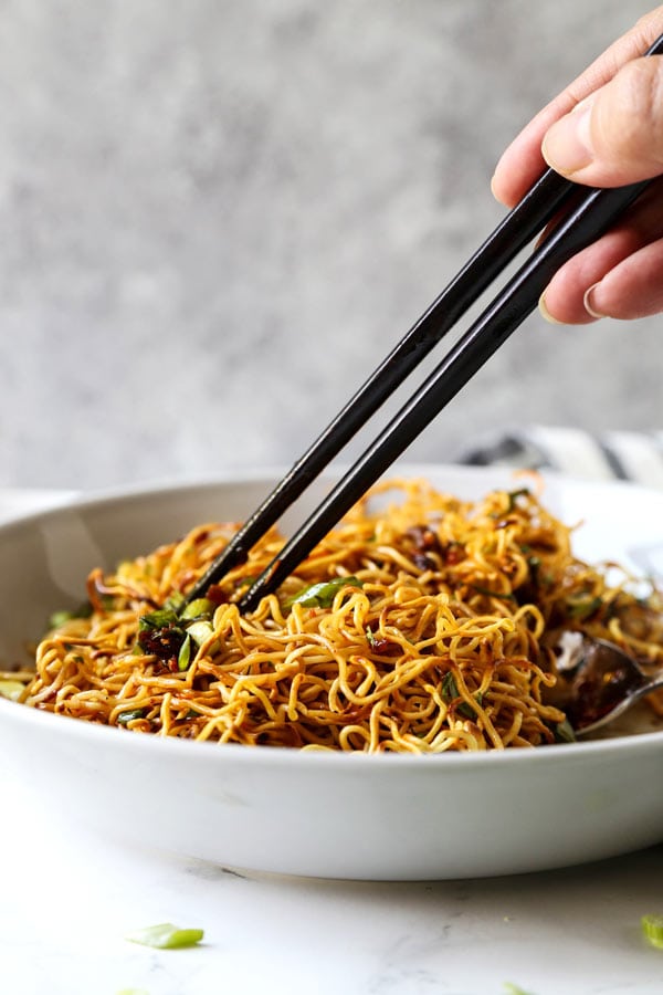 Pan Fried Noodles With Tangy Chili Crisp Sauce - Blanketed with herbs and plenty of smokey, pungent, fragrant heat, this pan fried noodles recipe is ready in under 20 minutes from start to finish! #eggnoodles #chineserecipes #noodlerecipe #stirfry #veganrecipes | pickledplum.com