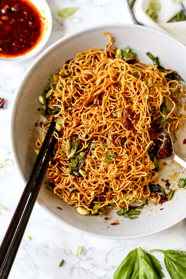 Pan Fried Noodles With Tangy Chili Crisp Sauce - Blanketed with herbs and plenty of smokey, pungent, fragrant heat, this pan fried noodles recipe is ready in under 20 minutes from start to finish! #eggnoodles #chineserecipes #noodlerecipe #stirfry #veganrecipes | pickledplum.com