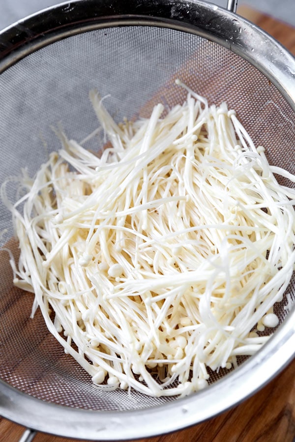 Champignons Enoki cuits au four (végétalien) - Cette délicieuse recette japonaise saine est pleine d'umami ! Cuits en papillote à la perfection, ces champignons enoki sont parfaits comme accompagnement pour le dîner, avec du tofu, ou garnis d'oignons verts. Tout simplement délicieux ! #japanesefood #veganrecipes #vegetarian #plantbased | pickledplum.com