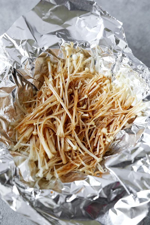 Gerocheerde Gebakken Enoki Paddenstoelen (Vegan) - Dit heerlijke gezonde Japanse recept zit boordevol umami! In folie gebakken tot in de perfectie, zijn deze enoki champignons perfect als bijgerecht bij het diner, samen met tofu, of gegarneerd met groene uien. Gewoonweg heerlijk! #japanesefood #veganrecipes #vegetarian #plantbased | pickledplum.com