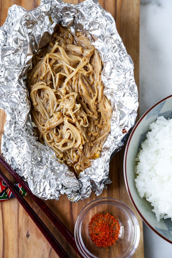 Setas Enoki al horno (veganas) -. Esta deliciosa y saludable receta japonesa está llena de umami. Horneados a la perfección, estos champiñones enoki son perfectos como acompañamiento para la cena, junto con el tofu, o cubiertos con cebollas verdes. ¡Simplemente delicioso! #comidajaponesa #recetasveganas #vegetarianas #basadas en plantas | pickledplum.com