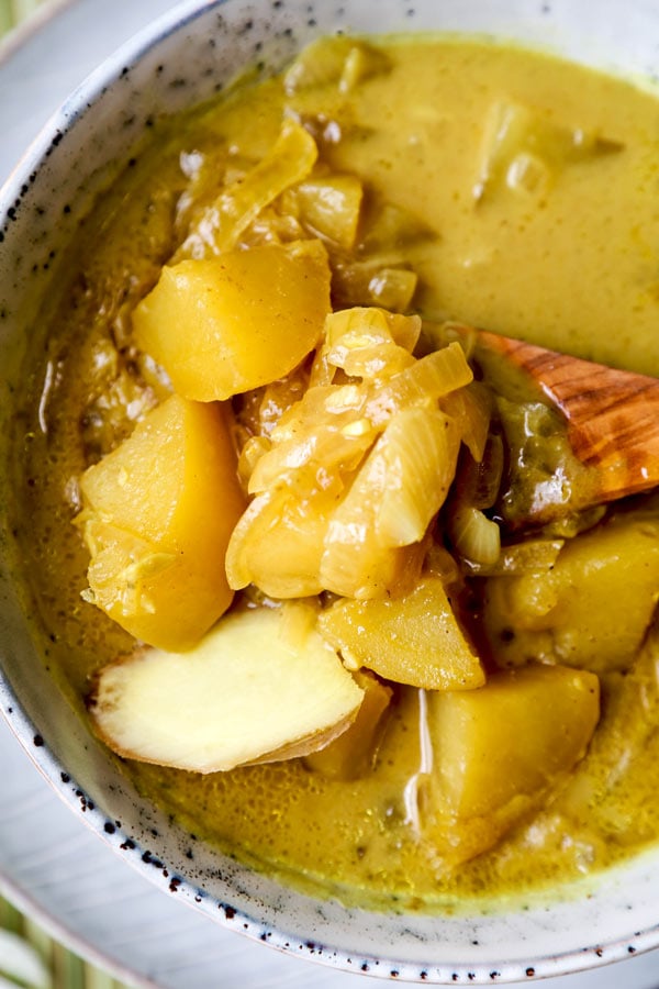 Thai Potato Curry (Vegan Recipe) - This is a quick and easy vegetarian curry loaded with potatoes and onions. It's an authentic Thai curry that's healthy and simple and only takes 30 minutes to make (from scratch). Yellow curry powder, soy sauce and coconut milk are the base of this vegan curry. Comforting, savory, delicious! #curryrecipes #healthyeating #thaifood #veganrecipes #vegetarianrecipes | pickledplum.com