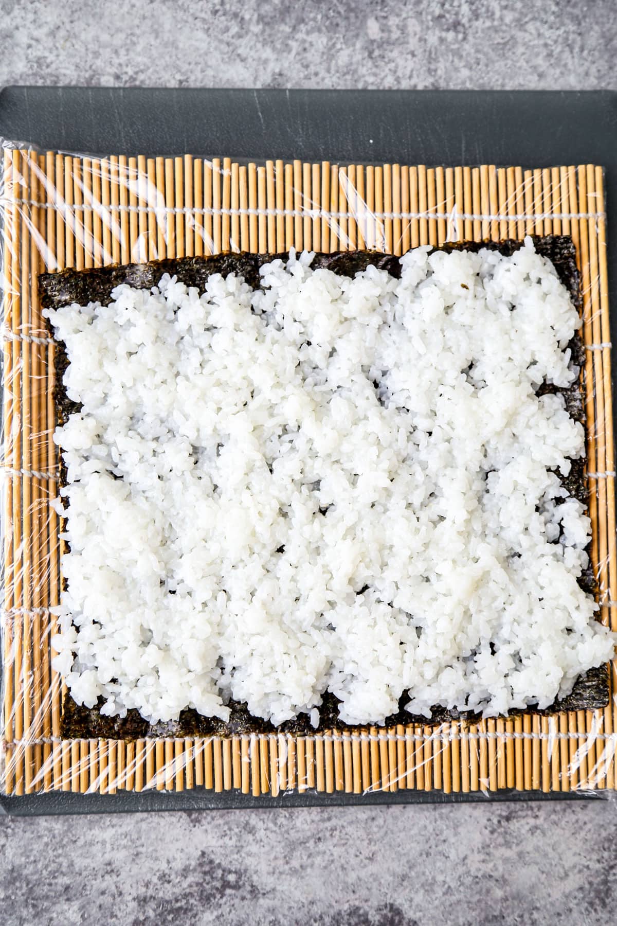 nori sheet and rice over bamboo mat