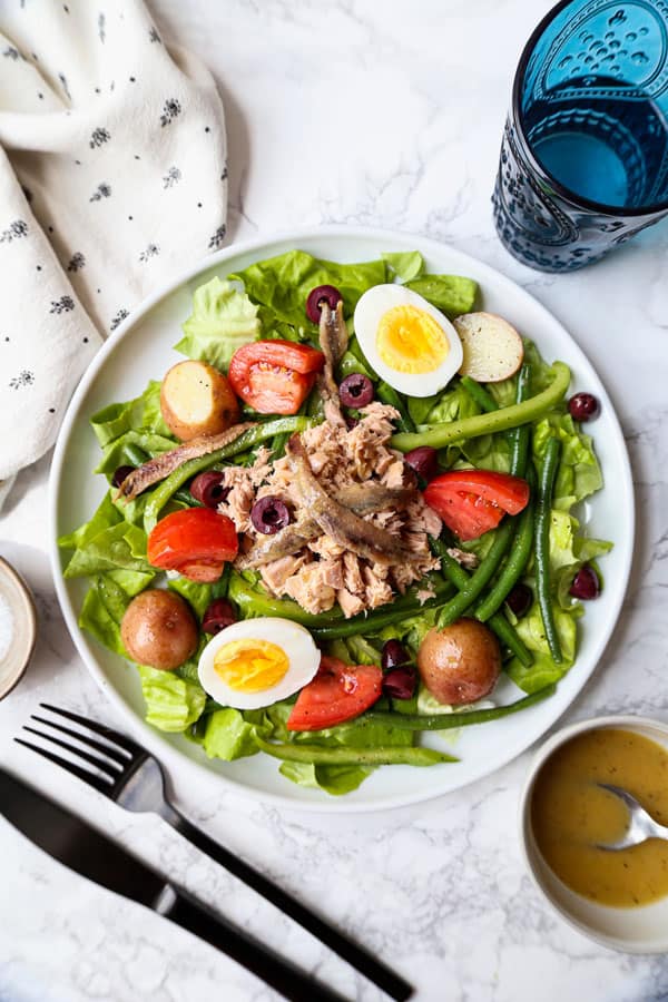 Nicoise salad with egg, tomatoes, green beans, potatoes, black olives and anchovies