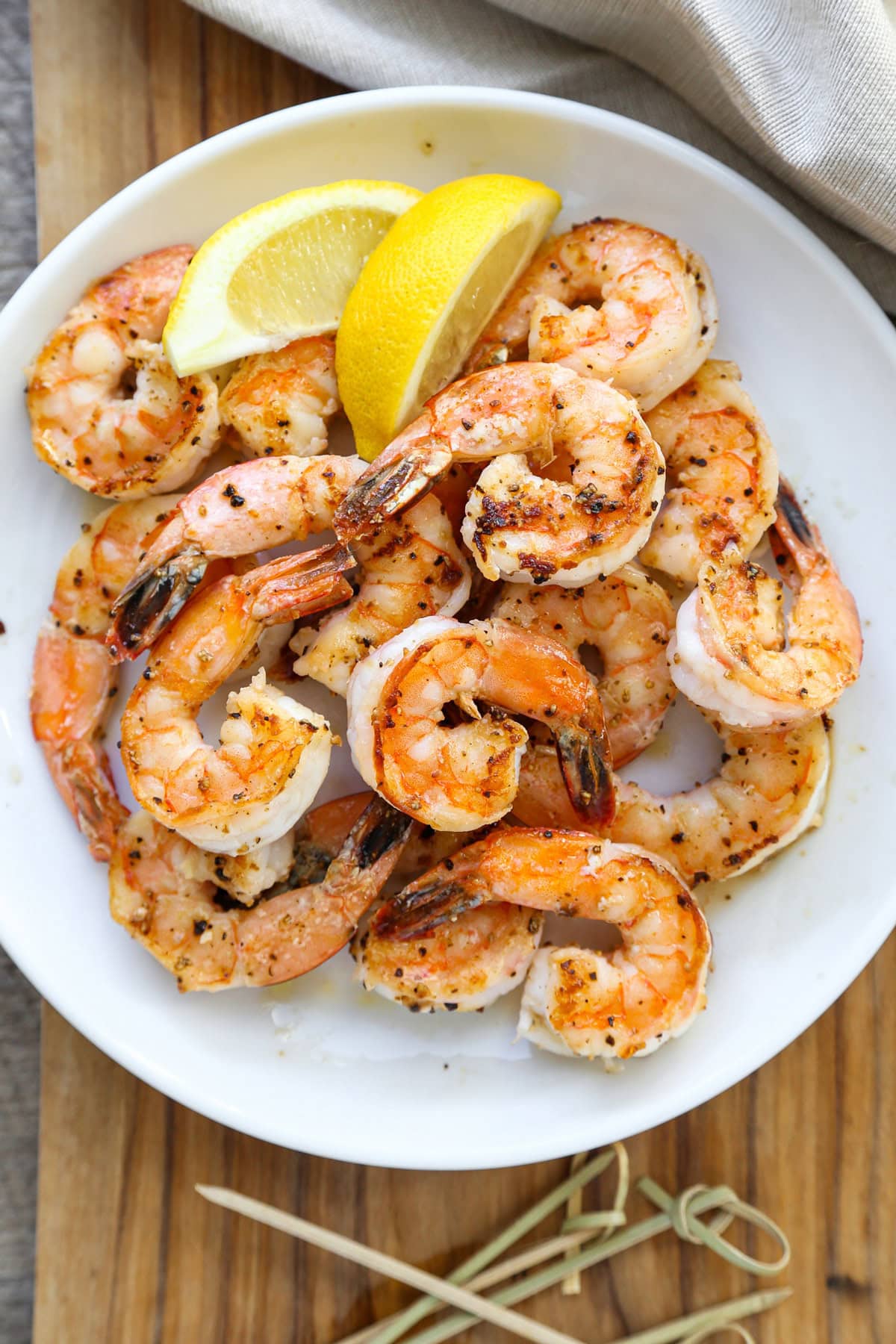 plate of garlic shrimp with lemon wedges