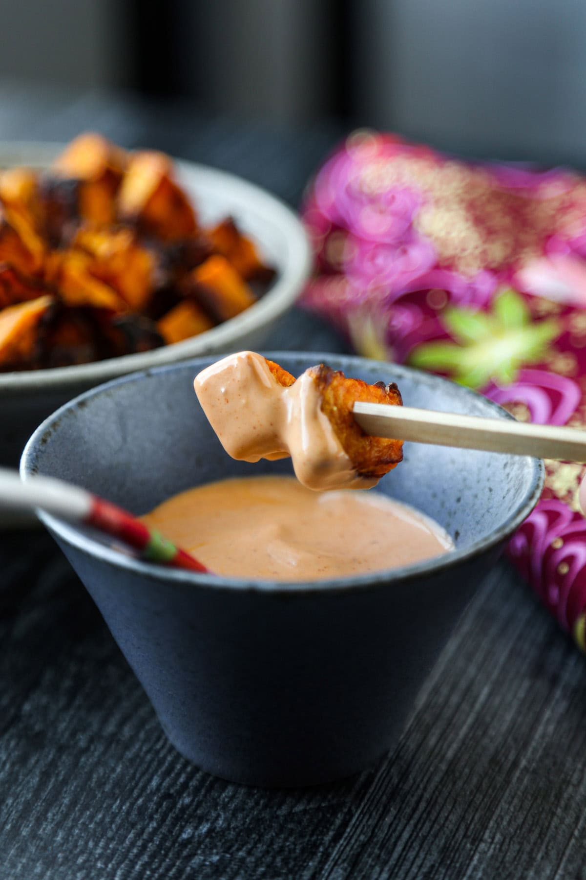 dipping sweet potatoes in sriracha mayo