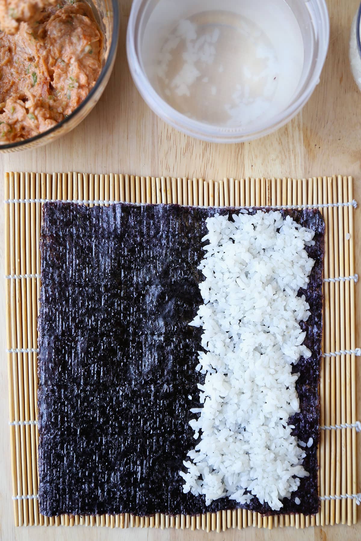 nori and rice over bamboo mat