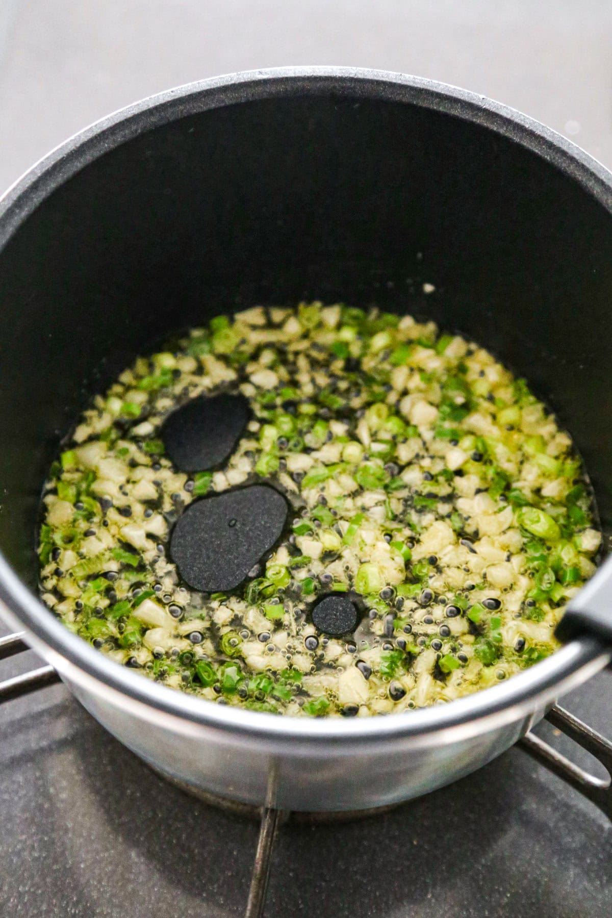 garlic and green onions frying in a pot